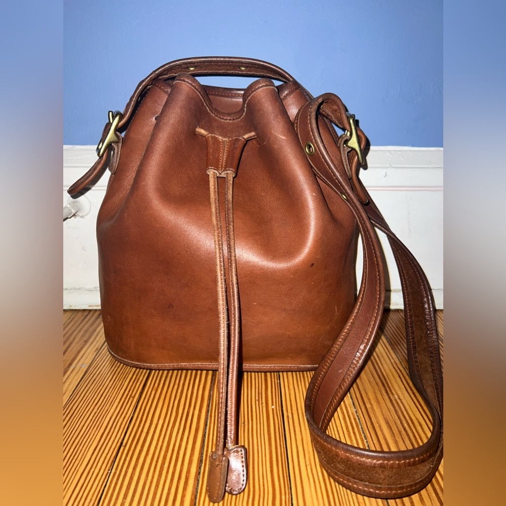 Authentic Coach Lulu’s Legacy British Tan Leather Drawstring bag. 

9952